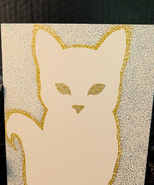 A seated cat in gold stippled outline with stippled facial features on white
