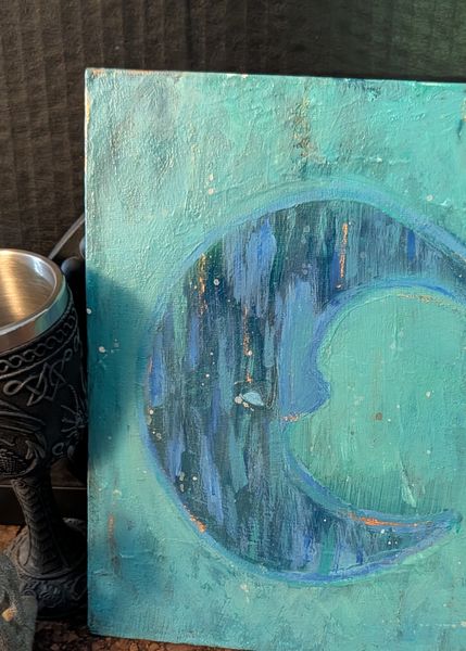 Crescent moon in deep blue over a teal ground