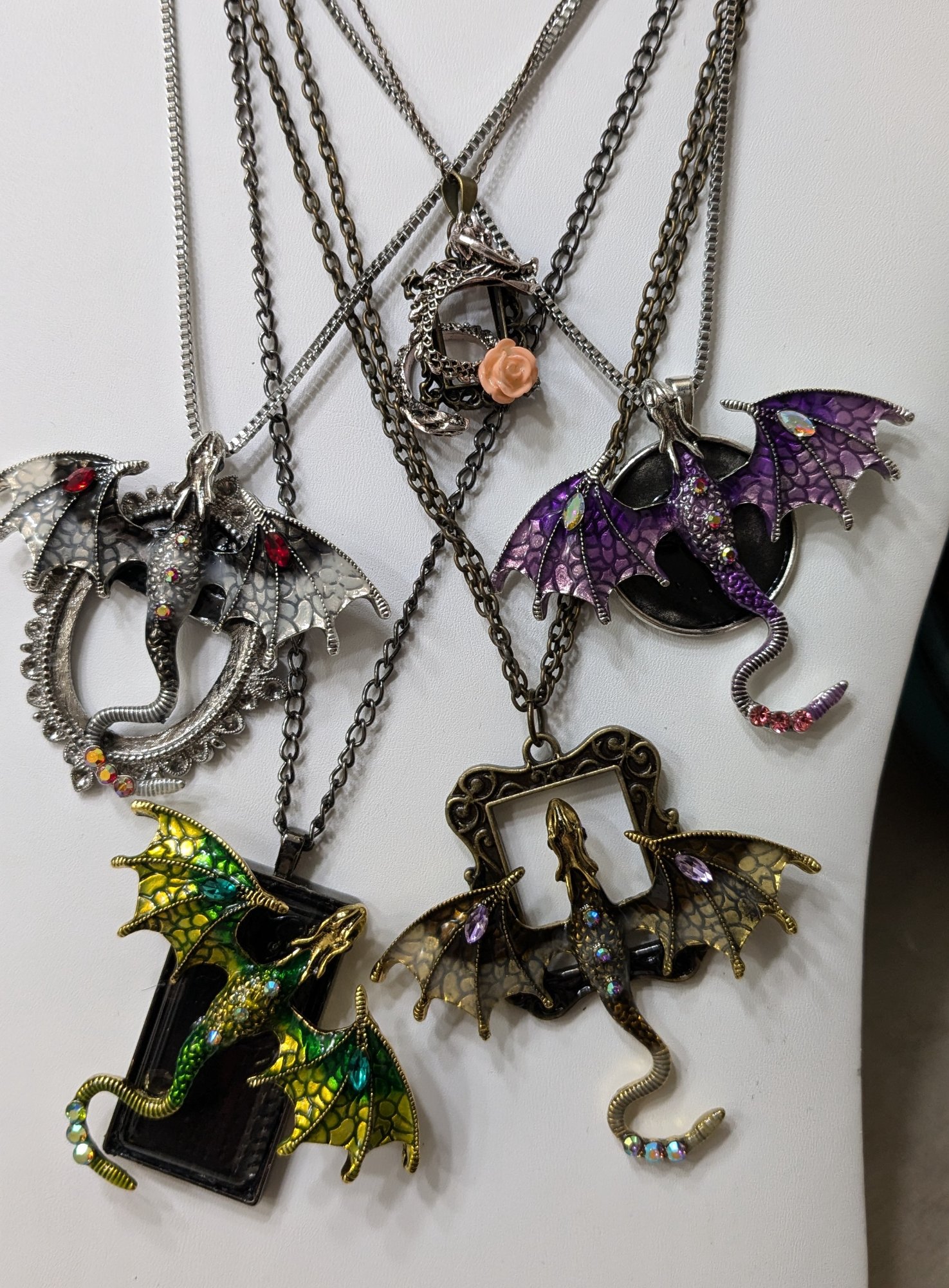 Dragon pendants in silver, purple, green, and bronze